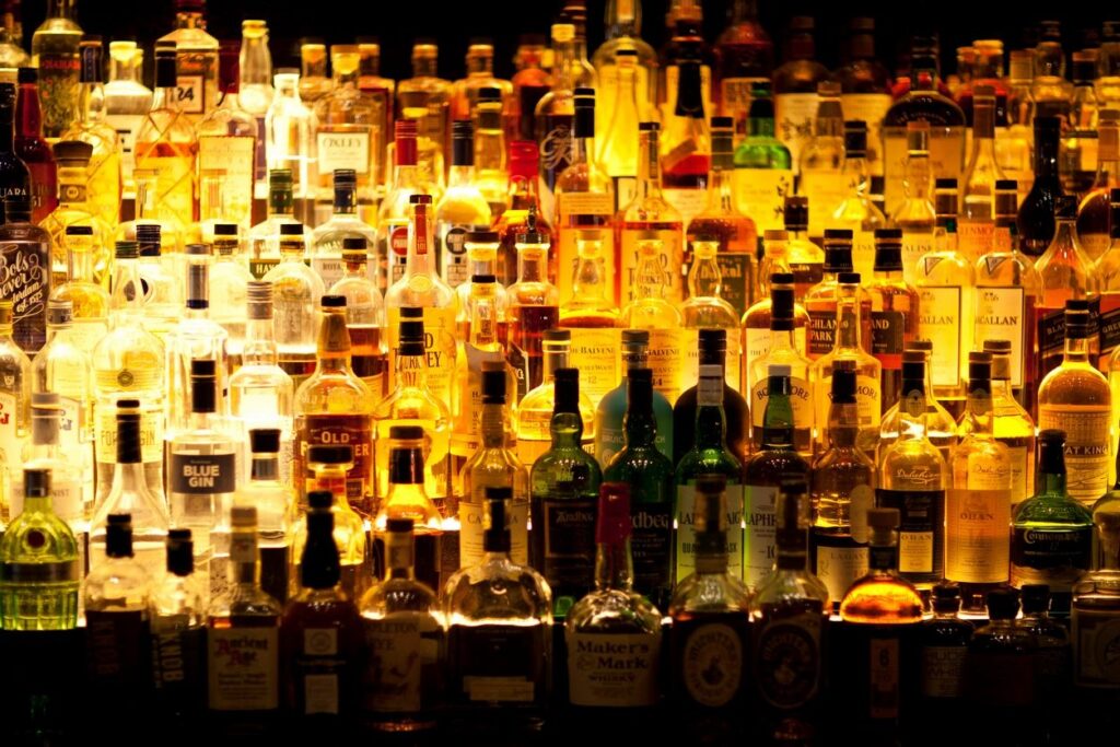 A bar filled with lots of bottles and glasses.