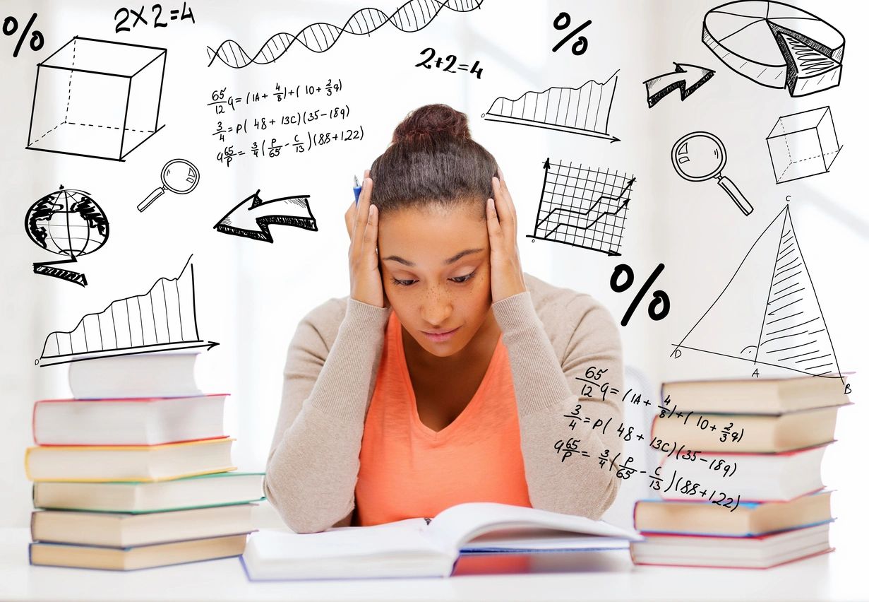 A girl is sitting at her desk with books