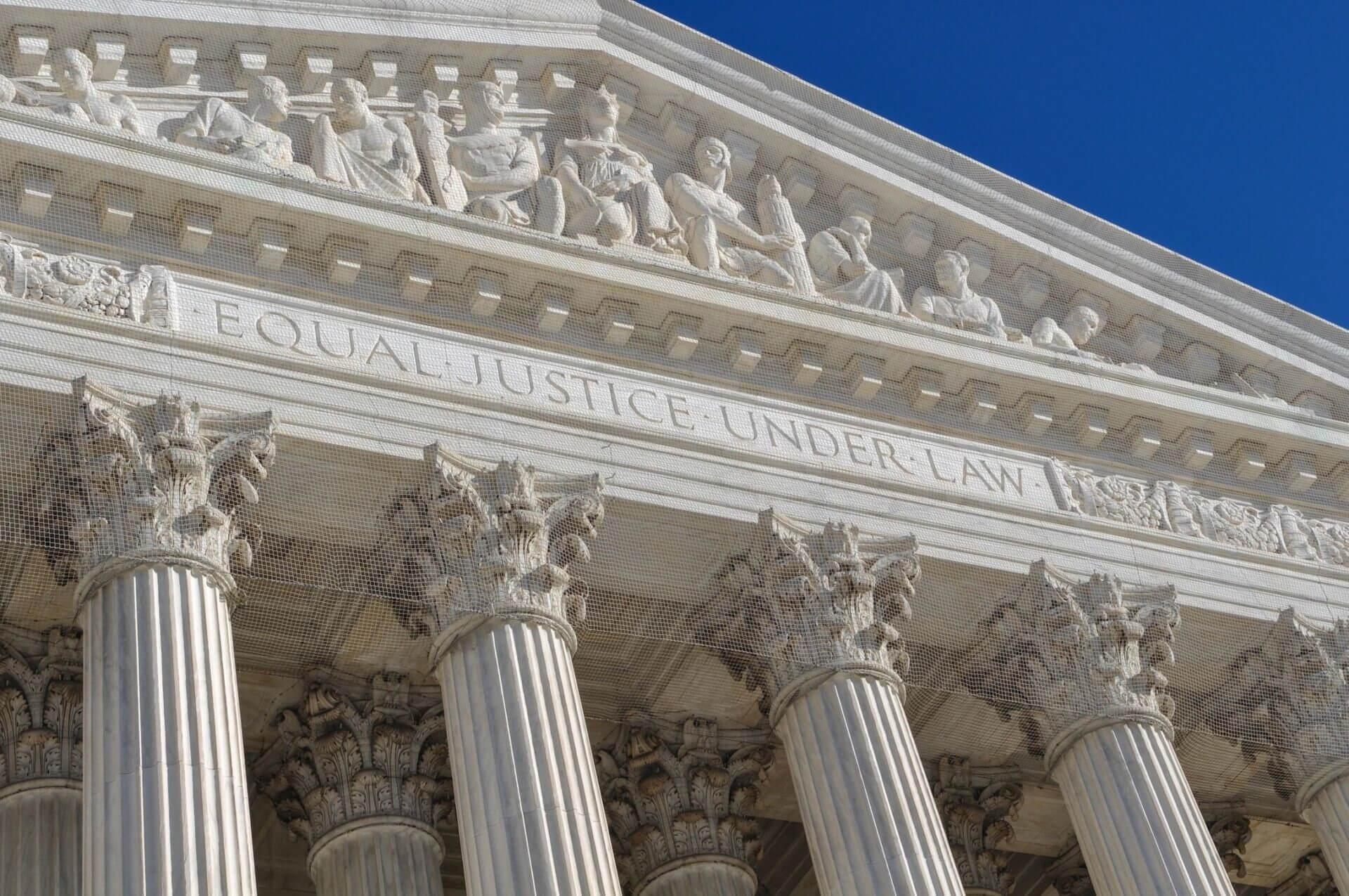 A close up of the front of a building with columns.